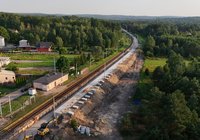 Z perspektywy lotu ptaka widok na modernizowany przystanek osobowy Berezów. Widoczne są nowy peron, linia kolejowa, prowadzone prace ziemne oraz otaczające tereny zielone i zabudowa.